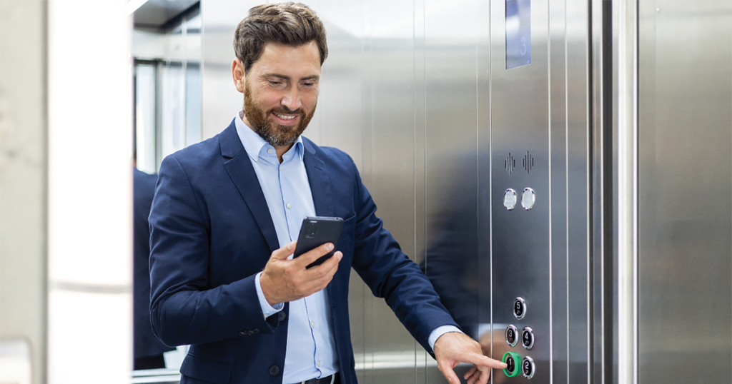 a man in a suit using a phone in an elevator